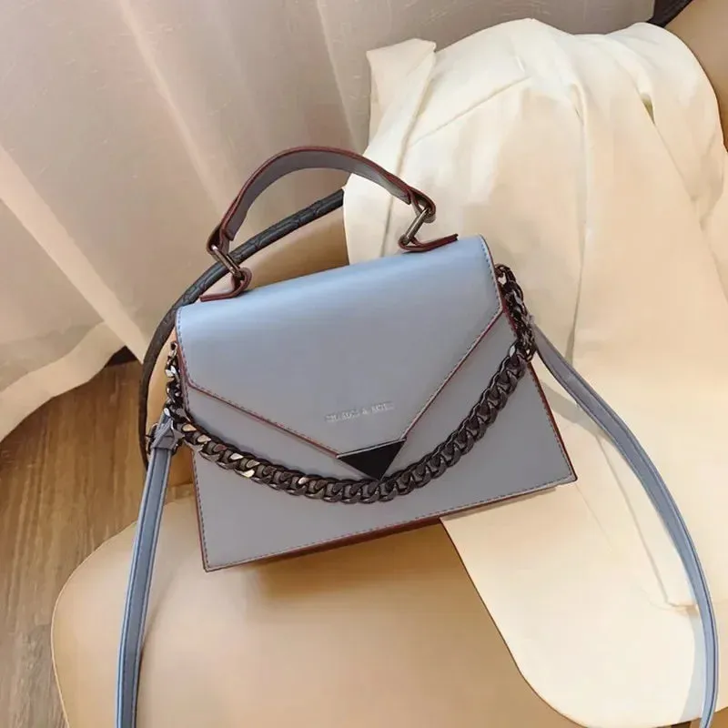 Bolso cruzado con textura y diseño con cadena, versátil.